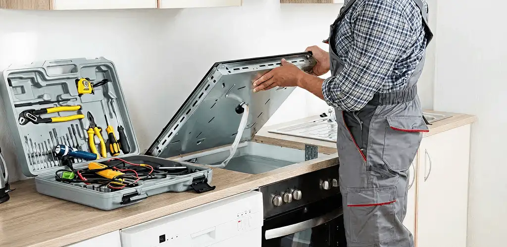 Handyman repairing a cooktop and checking wiring connections in Kansas City, MO