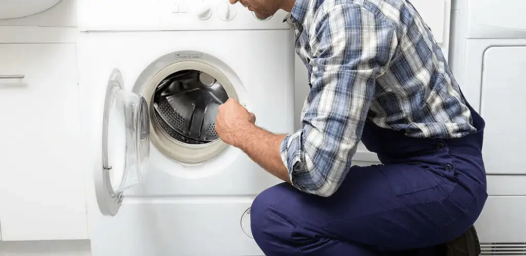 Handyman inspecting a dryer drum and internal parts for repair in Kansas City, MO
