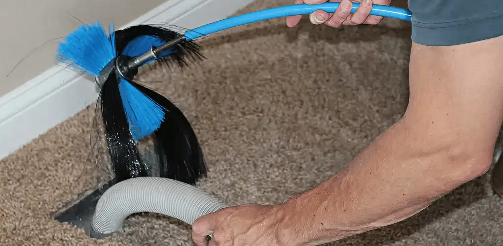 Dryer vent cleaning technician brushing lint from a vent line in Kansas City, MO
