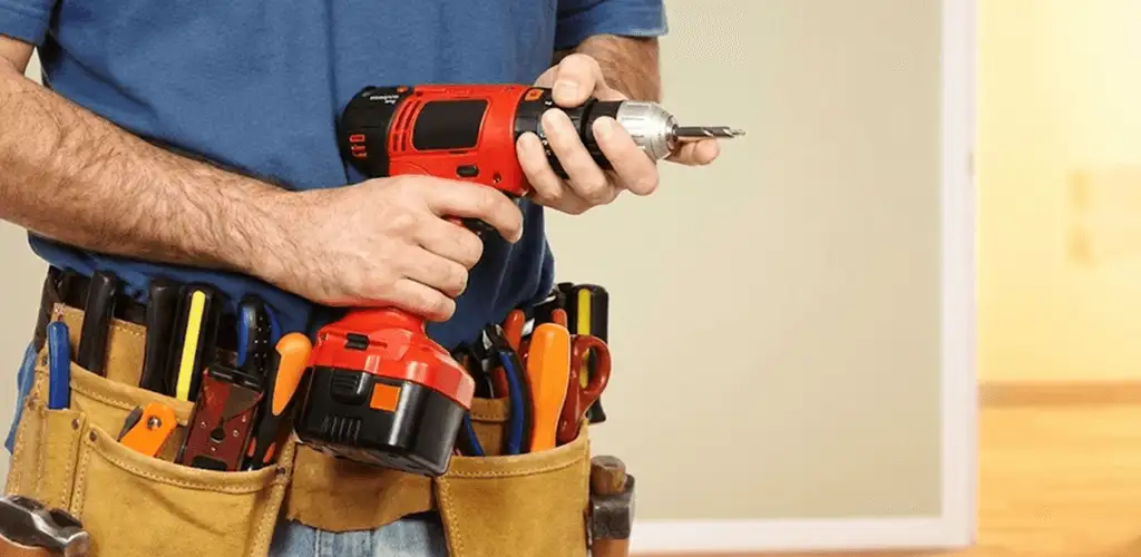 Handyman holding a power drill for home repairs and installations in Kansas City, MO