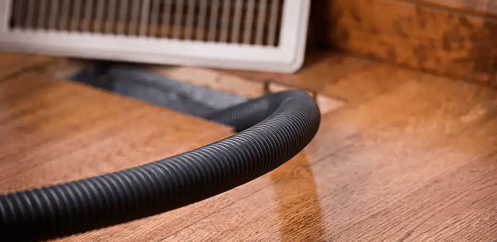 Air duct cleaning hose inserted into a floor vent for ductwork cleaning in Kansas City, MO